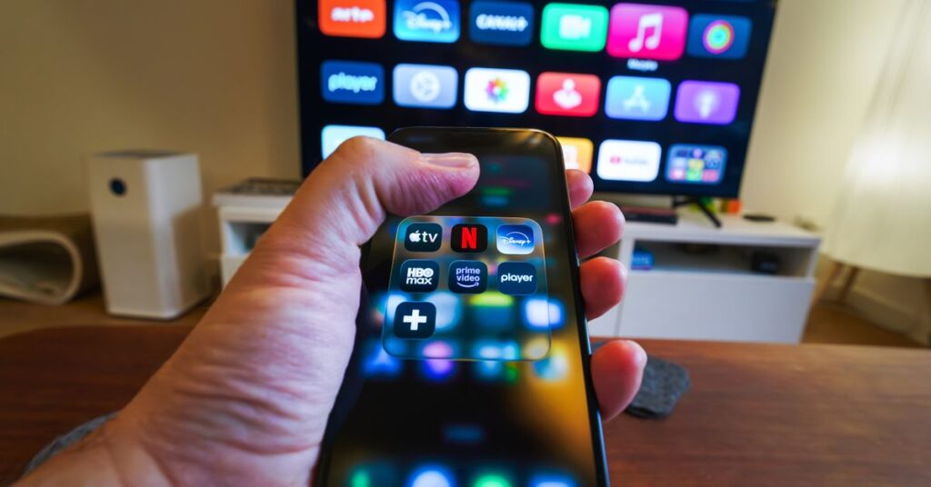 Person browsing the latest OTT releases on a streaming app with a TV remote